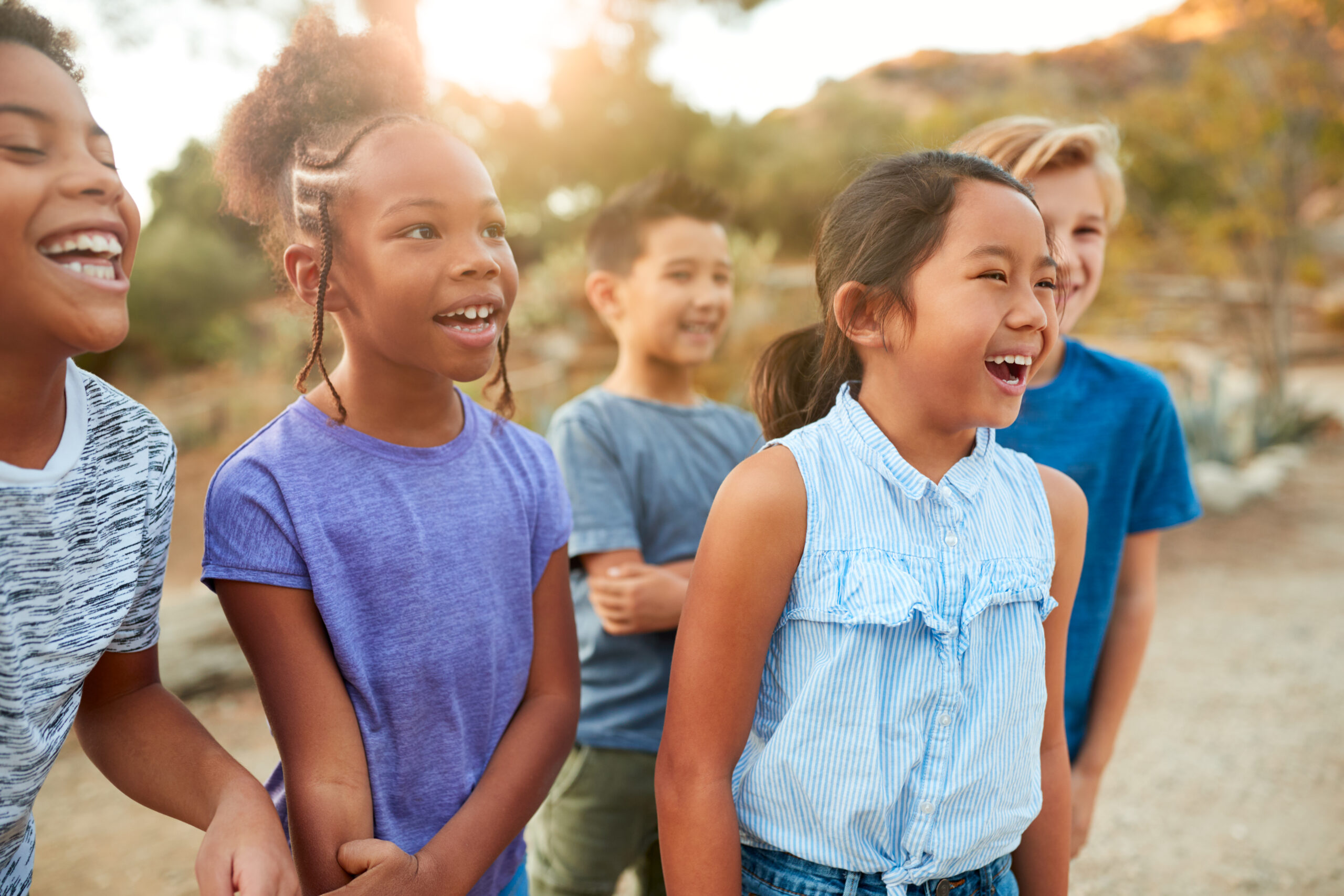 Group Of Multi-Cultural Children Posing And Hanging Out With Friends In Countryside Together